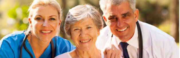 caregivers and old woman smiling